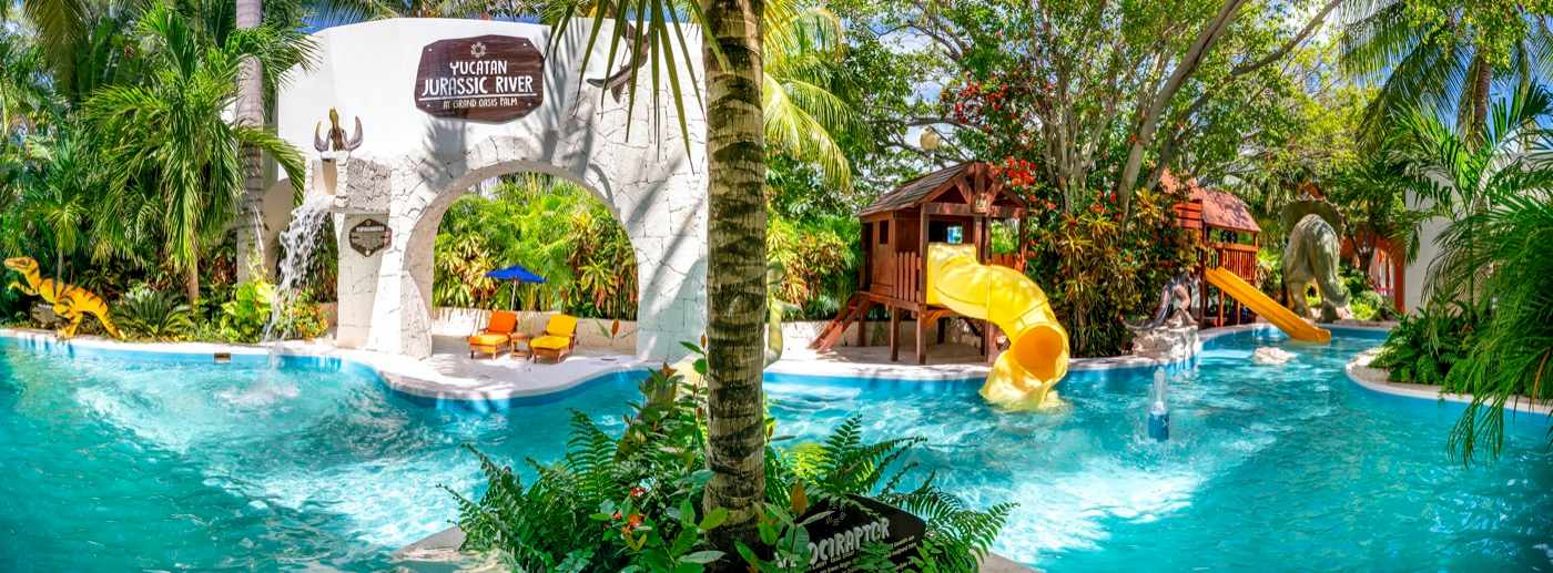 Beds under palm trees on the beach at Hotel Grand Oasis Palm